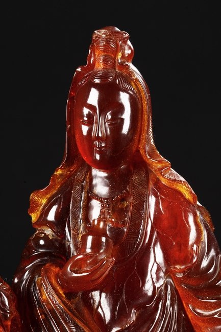 A VERY RARE CARVED AMBER FIGURE OF GUANYIN : Lot 59