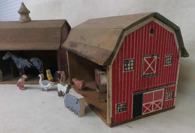 Two wooden toy barns including ten wooden farm animals ...